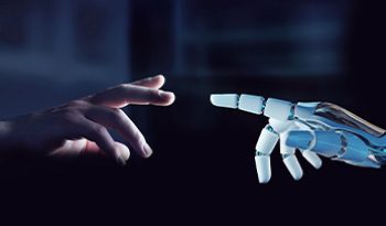 View of two worlds - a human hand and a mechanized robot hand