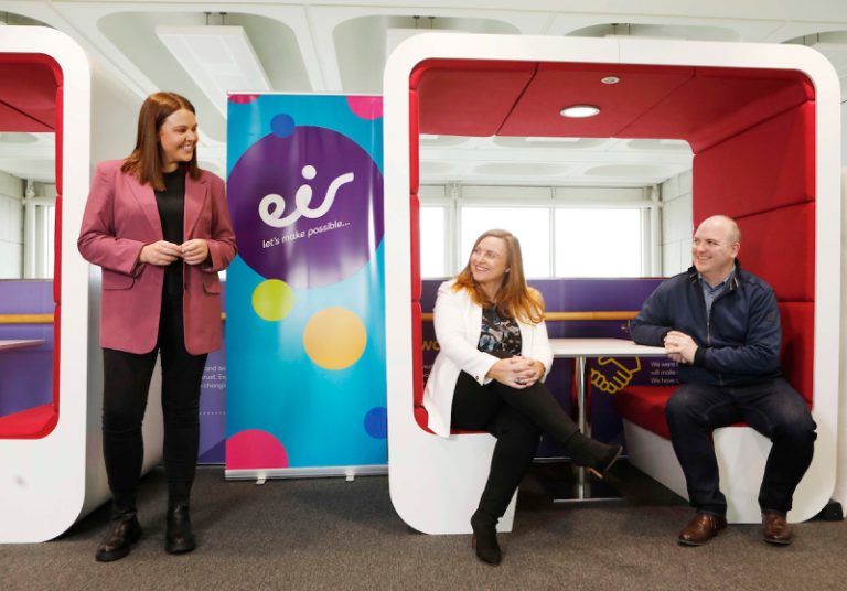 Three people chatting in eir office