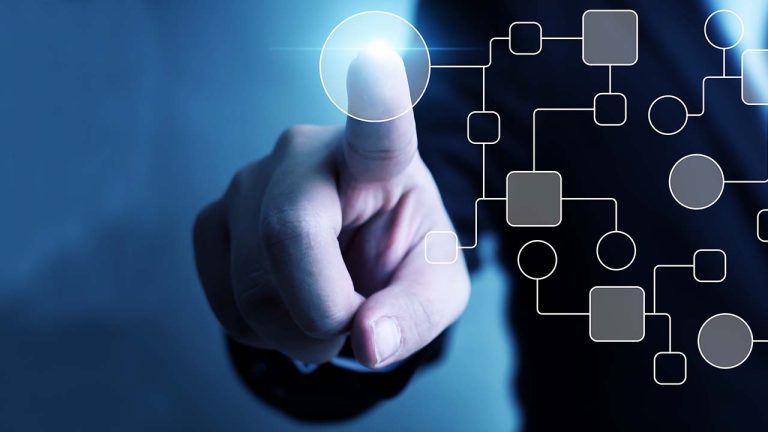 A person interacts with a futuristic digital interface, pointing to a glowing node on a transparent screen with branching network diagrams, highlighting modern technology and connectivity.