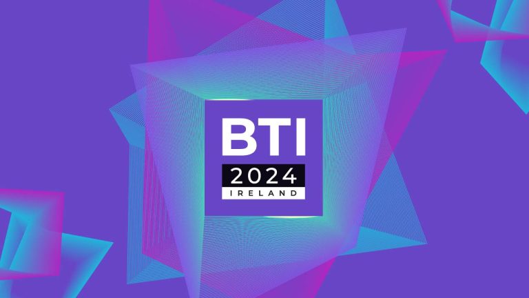 A vibrant geometric design with overlapping pink, teal, and purple shapes. In the center, a square contains "BTI" in large white letters above "2024" and "IRELAND" in smaller white text on a black background. The overall background is purple.