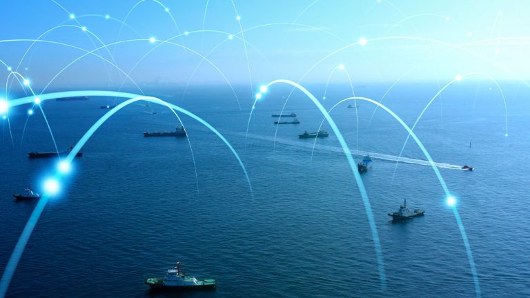 Aerial view of the ocean with multiple cargo ships scattered across the water. Overlaid digital arcs and nodes symbolize maritime communication and logistics networks. The sky is clear, blending with the sea at the horizon.