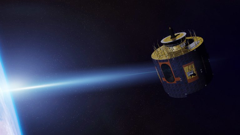 A satellite orbits Earth, illuminated by sunlight. The planet's horizon glows against the dark backdrop of space. The satellite features a cylindrical body with various protruding antennas and equipment.