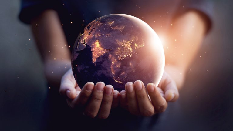 A person holding globe of the Earth