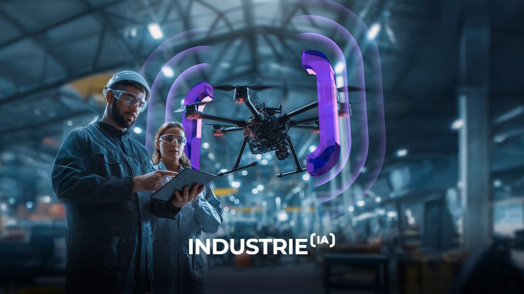Two engineers in safety gear review a clipboard as a drone with purple sensors hovers nearby in a modern industrial factory. The word “INDUSTRIE” appears at the bottom of the image.