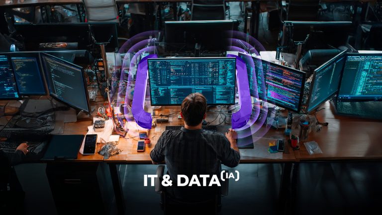 A person sits at a desk with multiple computer monitors displaying code. Purple digital waves surround the screens. The text "IT & DATA (IA)" appears at the bottom. The workspace is filled with tech equipment.