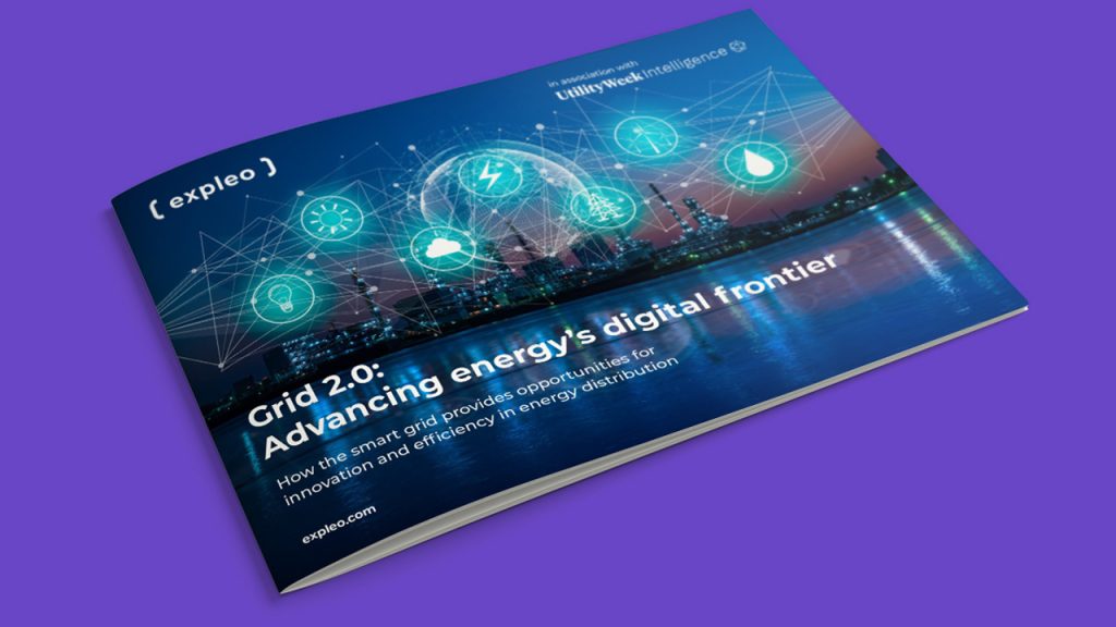 A booklet titled "Grid 2.0: Advancing energy's digital frontier" lies on a purple surface, featuring a city skyline, digital icons for energy, and network connections on its cover.