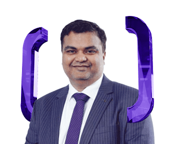 A man in a business suit and tie smiles at the camera, standing between two large, purple, translucent bracket symbols on a white background.